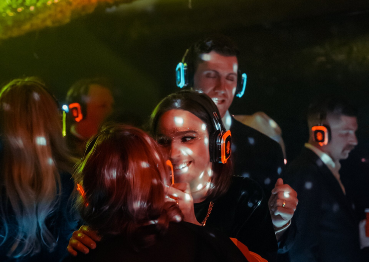 a group of people are dancing at a party wearing Silent Disco
