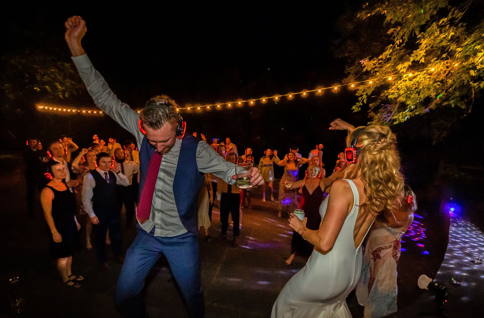 wedding couple dancing in front of their guests with silent disco headphones on