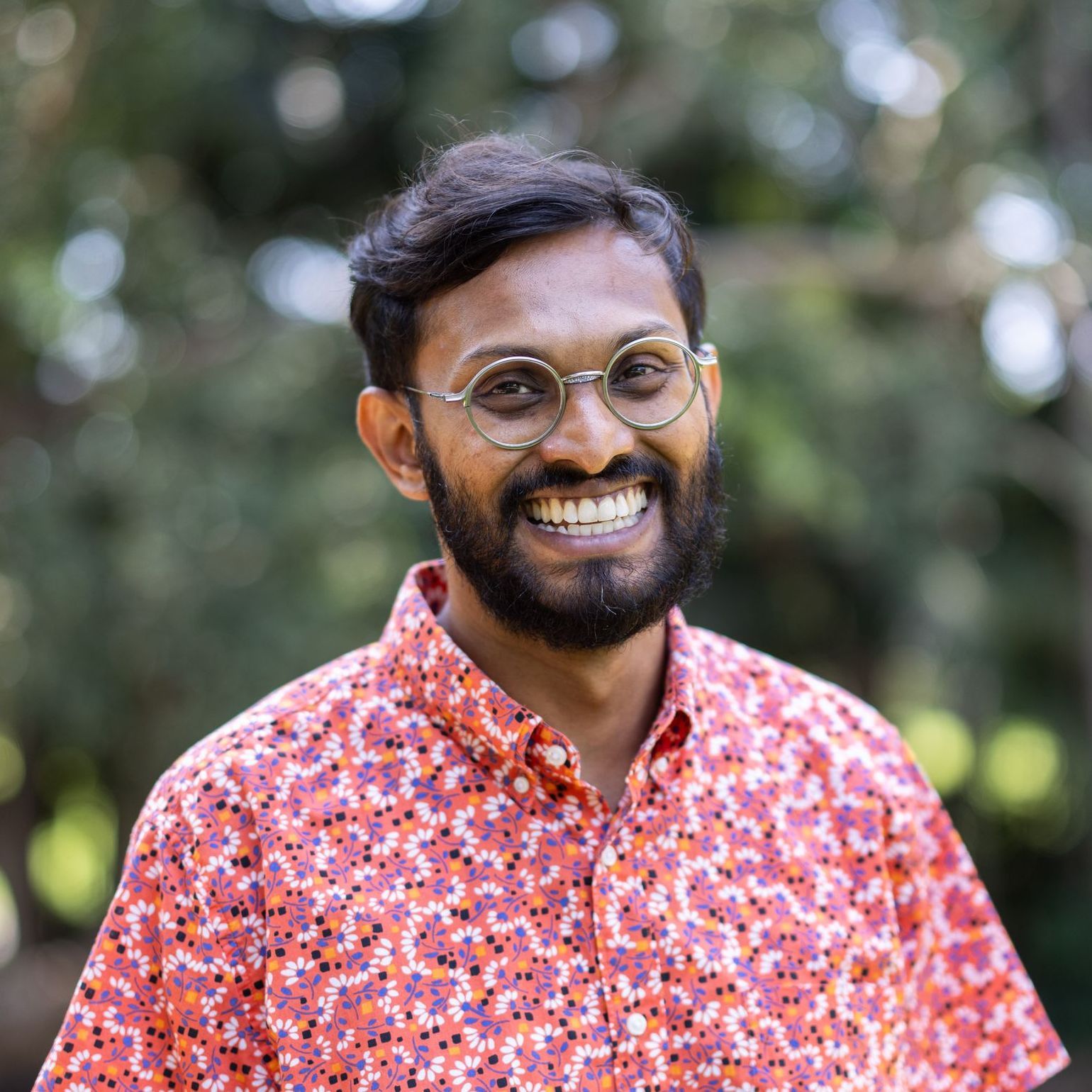 A man with a beard and glasses is smiling for the camera.