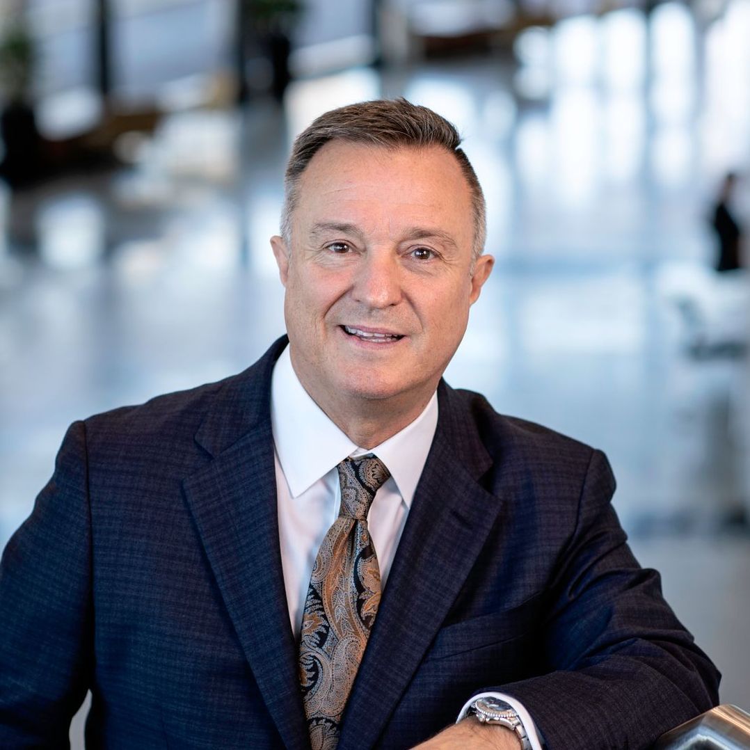 A man in a suit and tie is smiling for the camera.