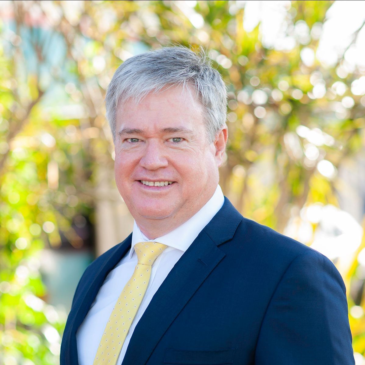 A man in a suit and tie is smiling for the camera.