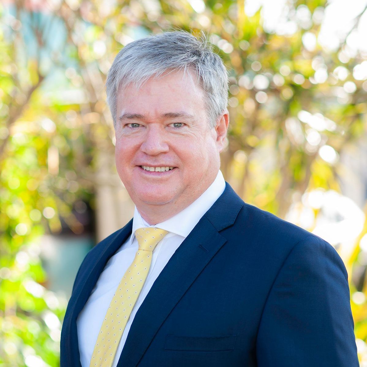 A man in a suit and tie is smiling for the camera.