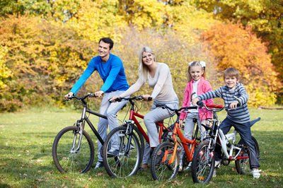 A family is riding bicycles in a park.
