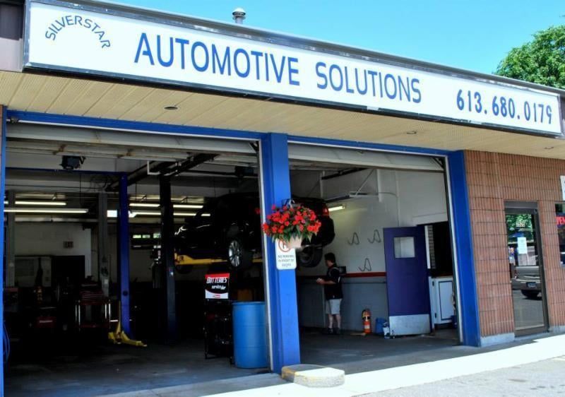 Automotive Solutions storefront with open garage bays and blue trim