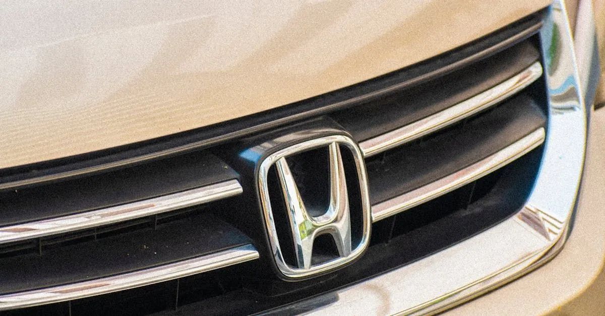 Close-up of a silver Honda grille and emblem on a beige car front