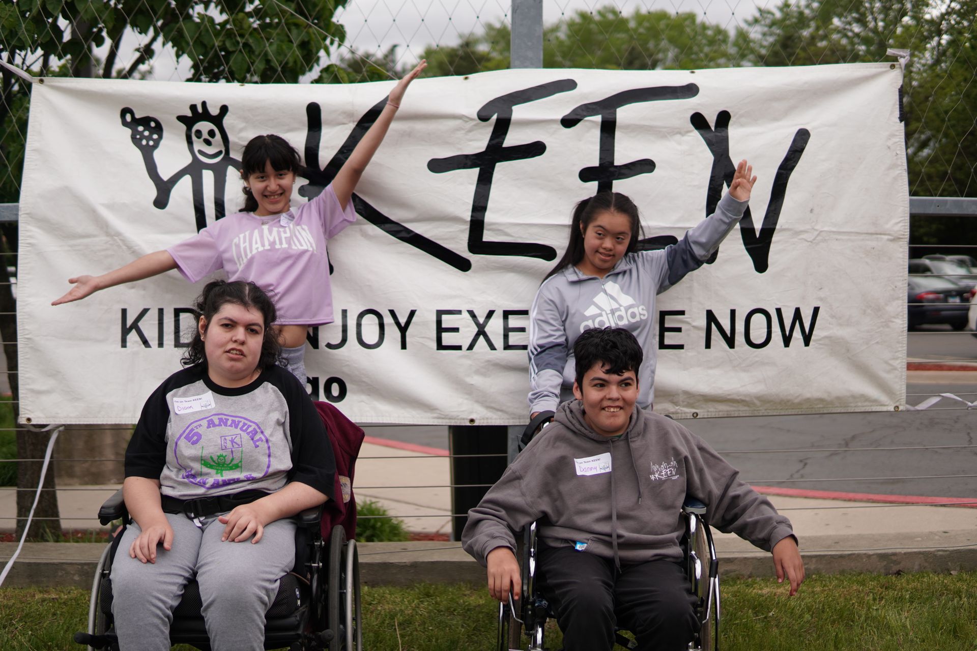 Four KEEN athletes pose together in front of the KEEN Chicago banner
