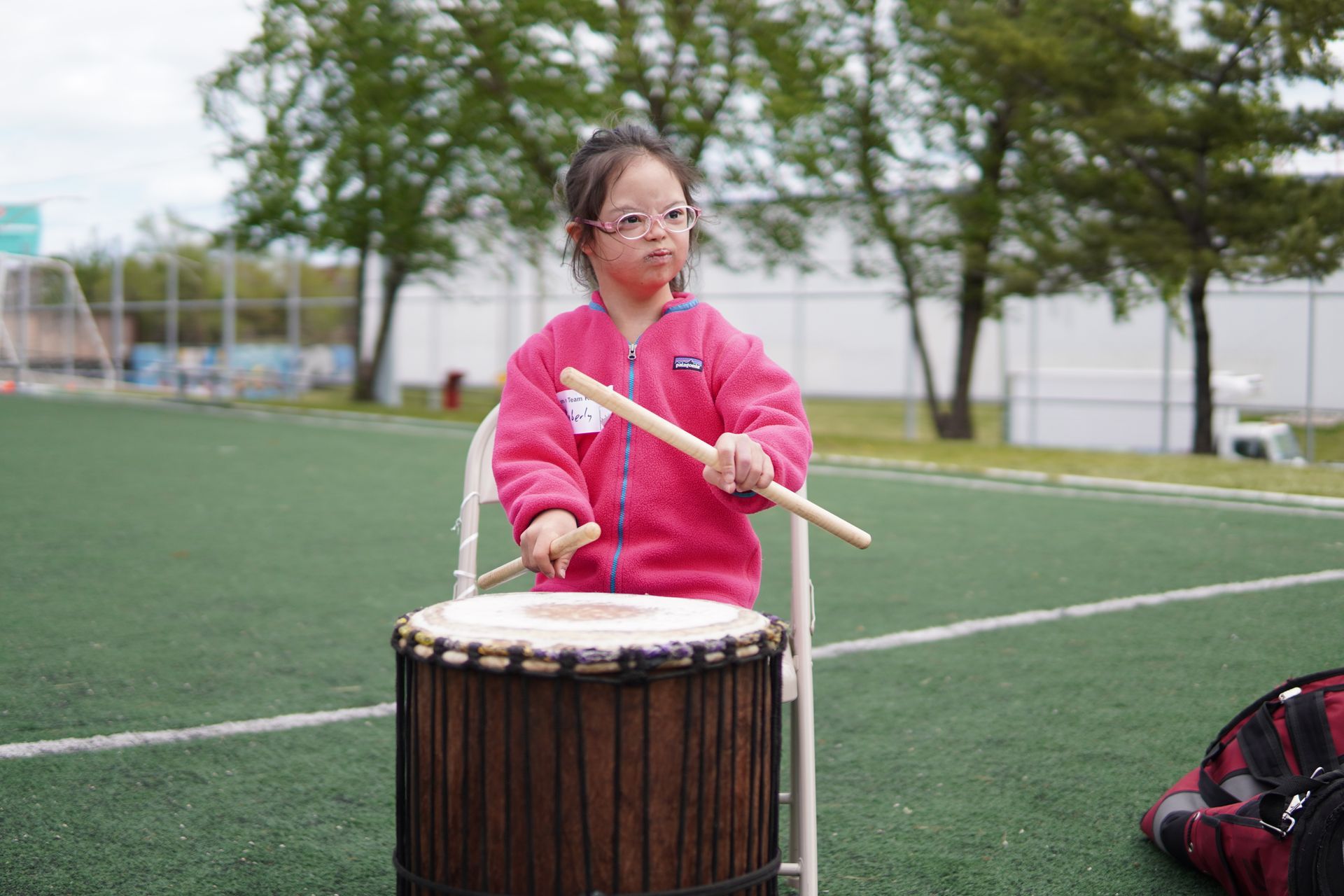 A youth KEEN athlete plays with a drum