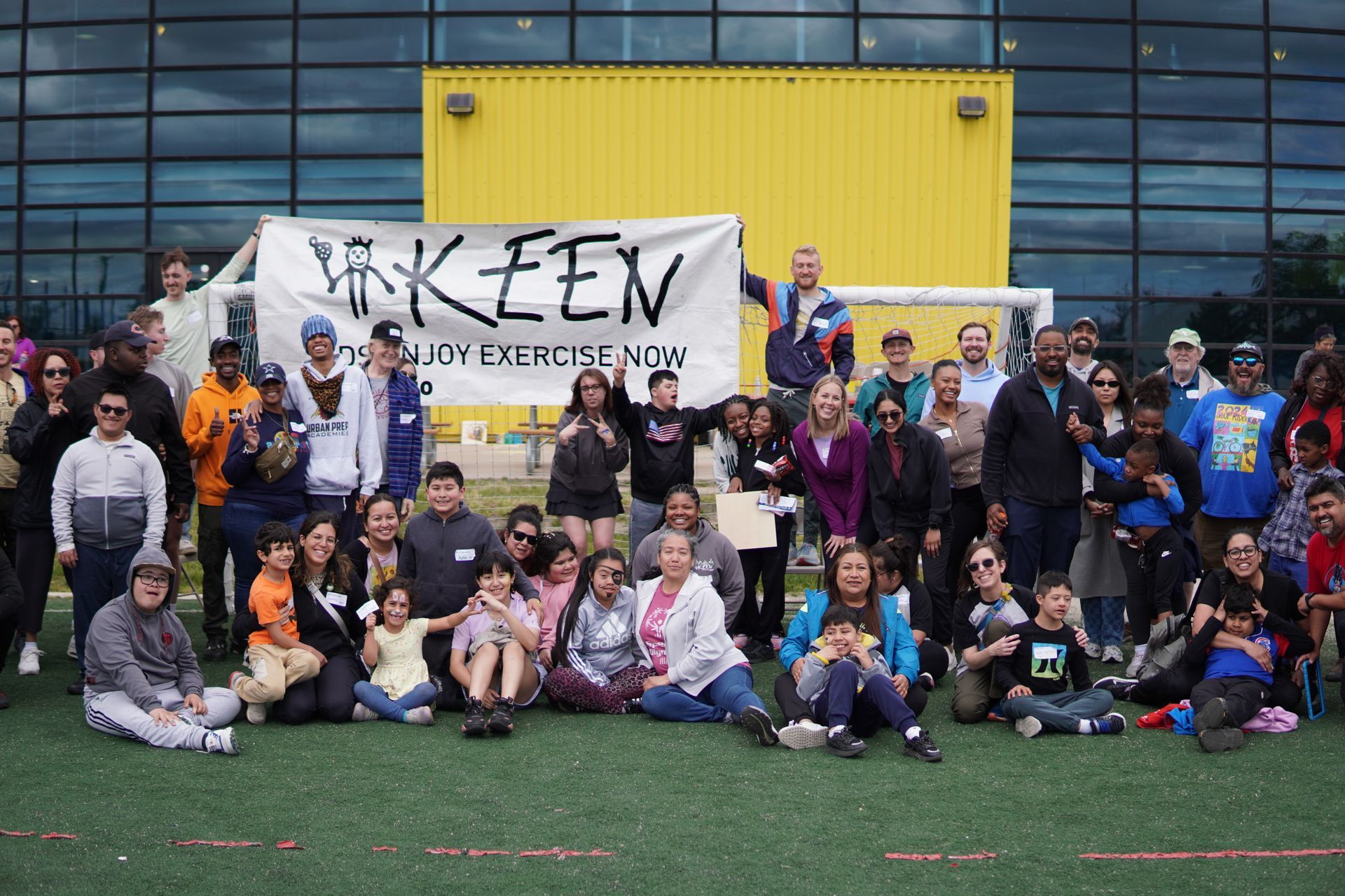 Large group of attendees pose together in front of the KEEN Chicago banner