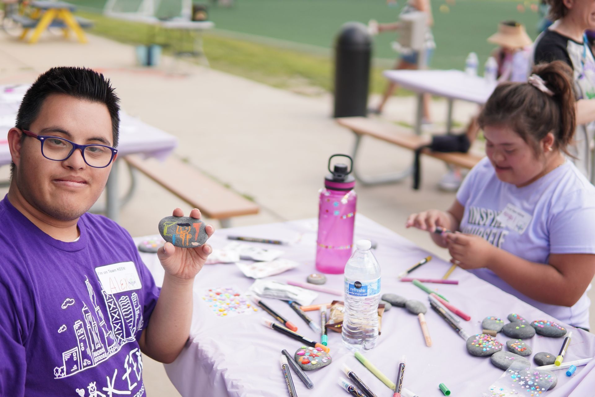 Two event attendees participate in a sensory rock painting art project