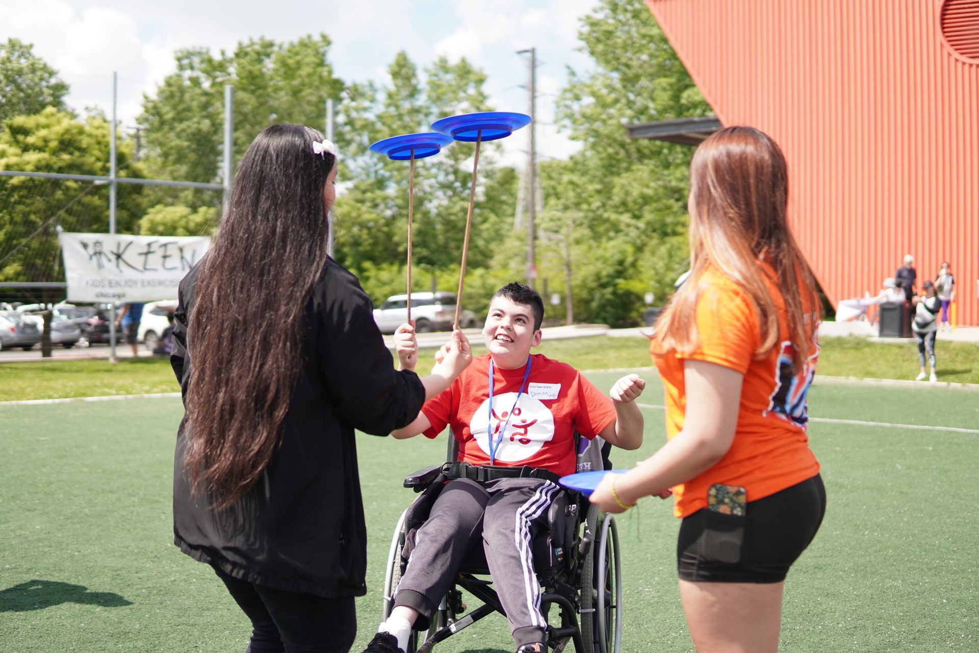 A teenager in a wheelchair practices plate spinning during a circus skills workshop