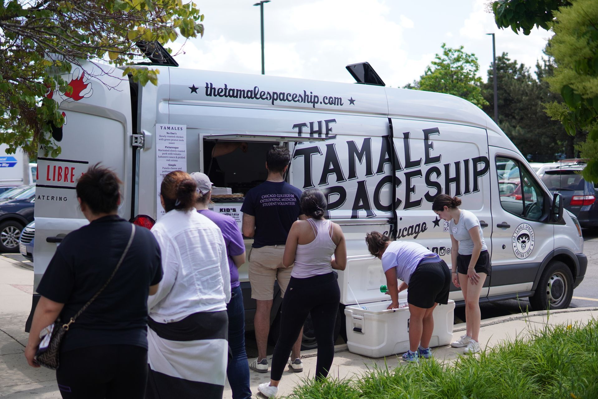 Attendees wait in line in front of The Tamale Spaceship food truck which provided food at the event.