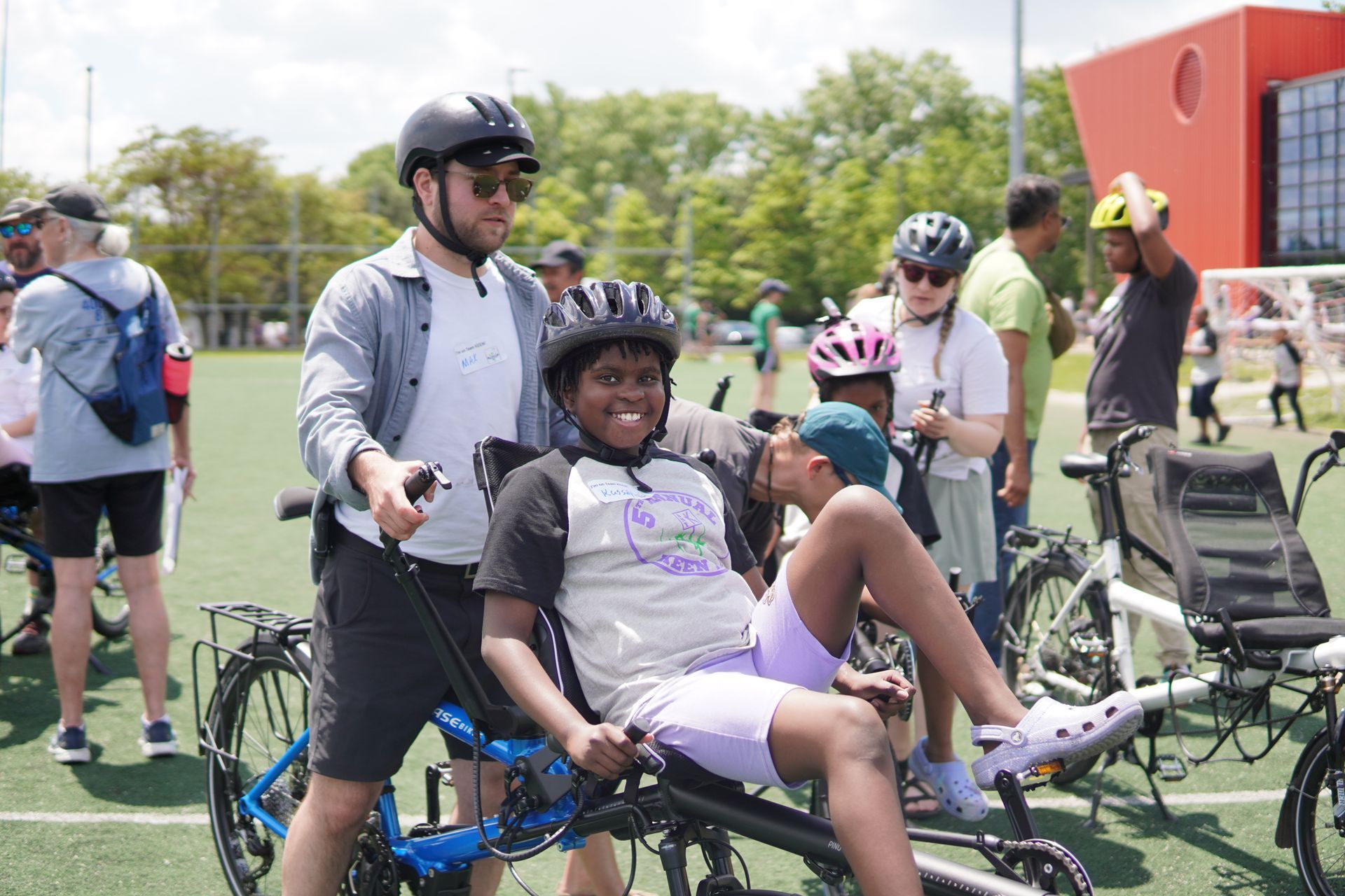 A young girl prepares to ride on an adaptive bike