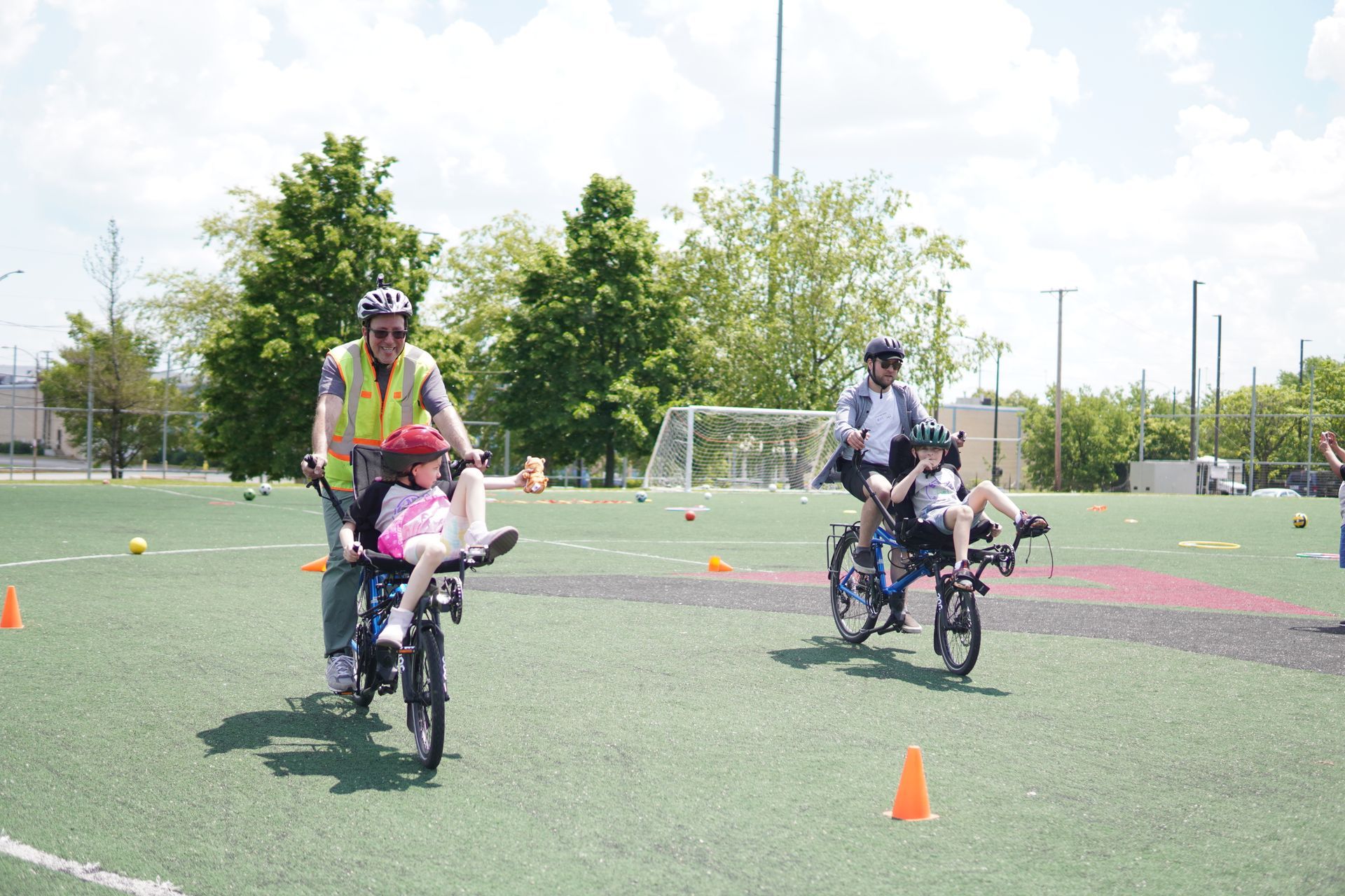 Two event participants ride adaptive bikes.