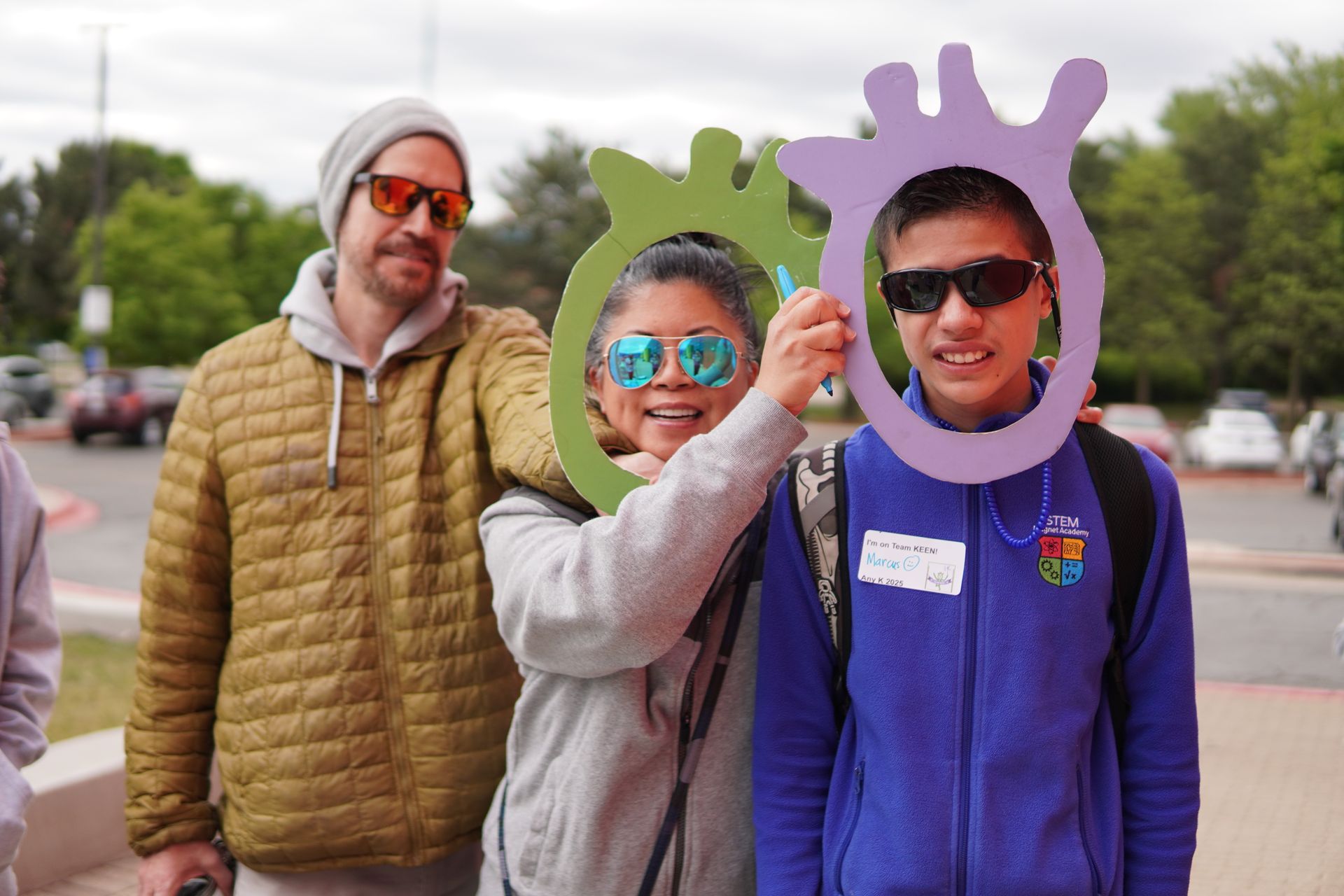 A family poses for a photo with KEEN mascot cutouts.
