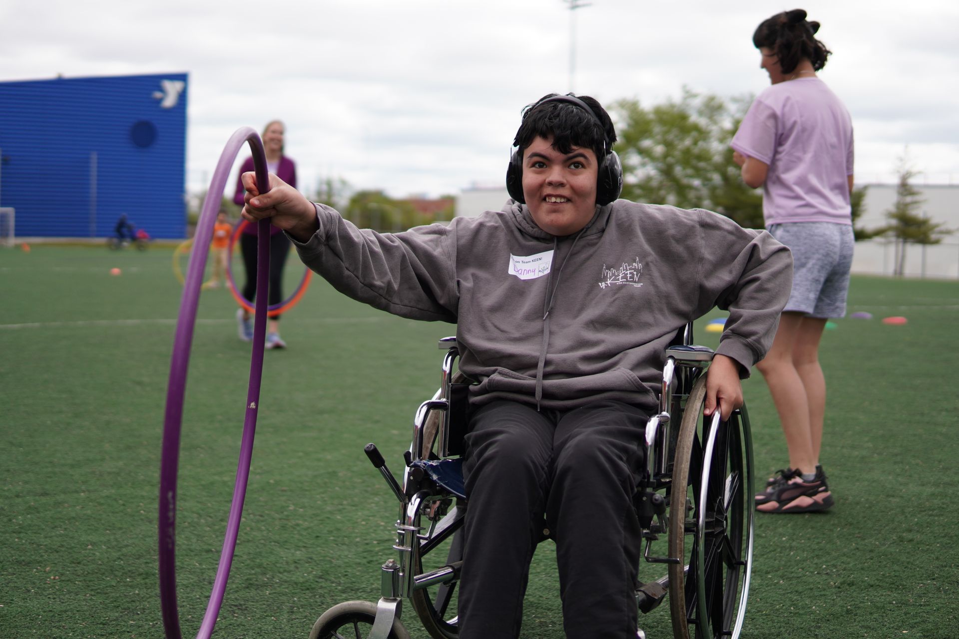 Boy in a wheelchair plays with a hula hoop