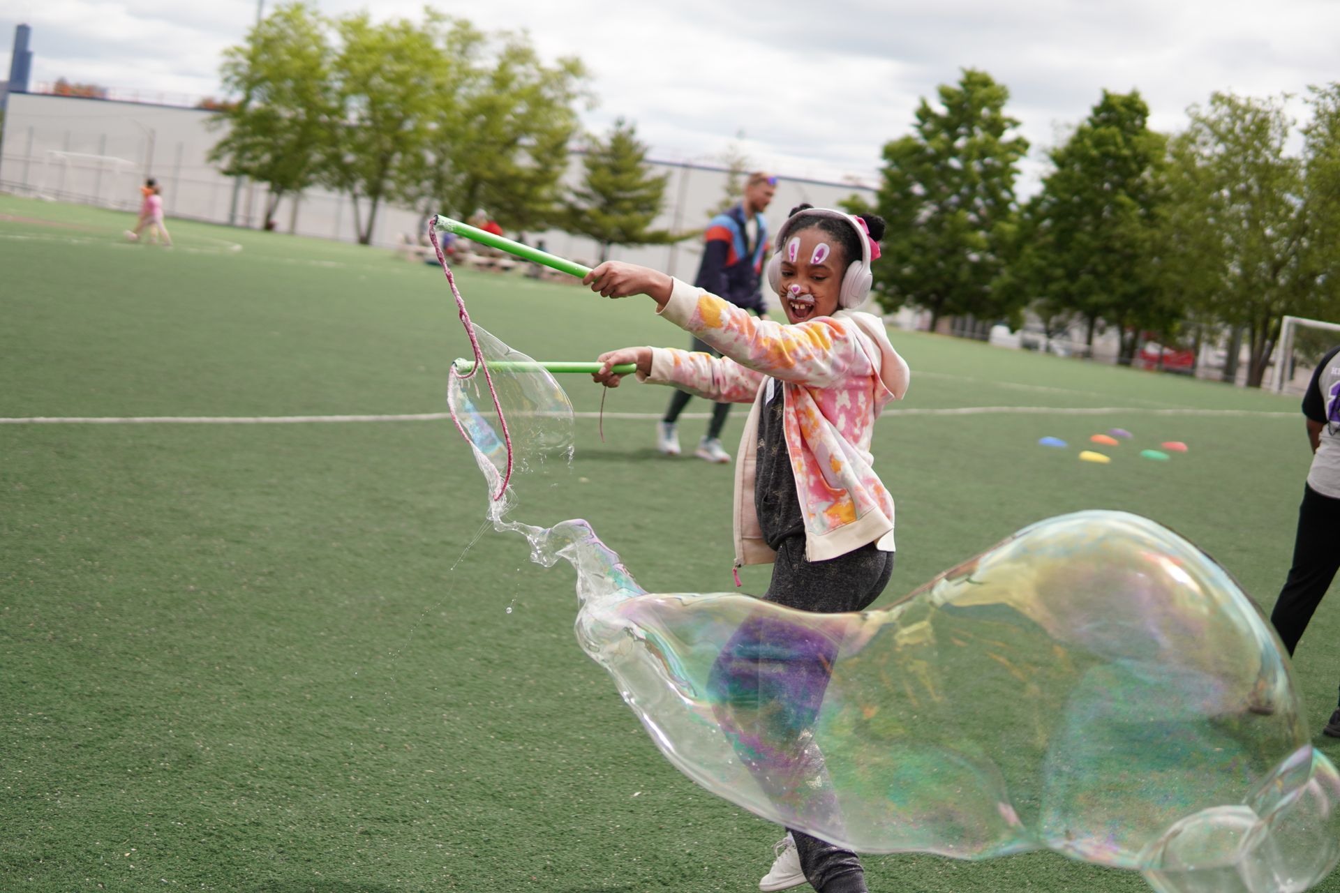 Teenage girl blows a giant bubble utilizing a wand