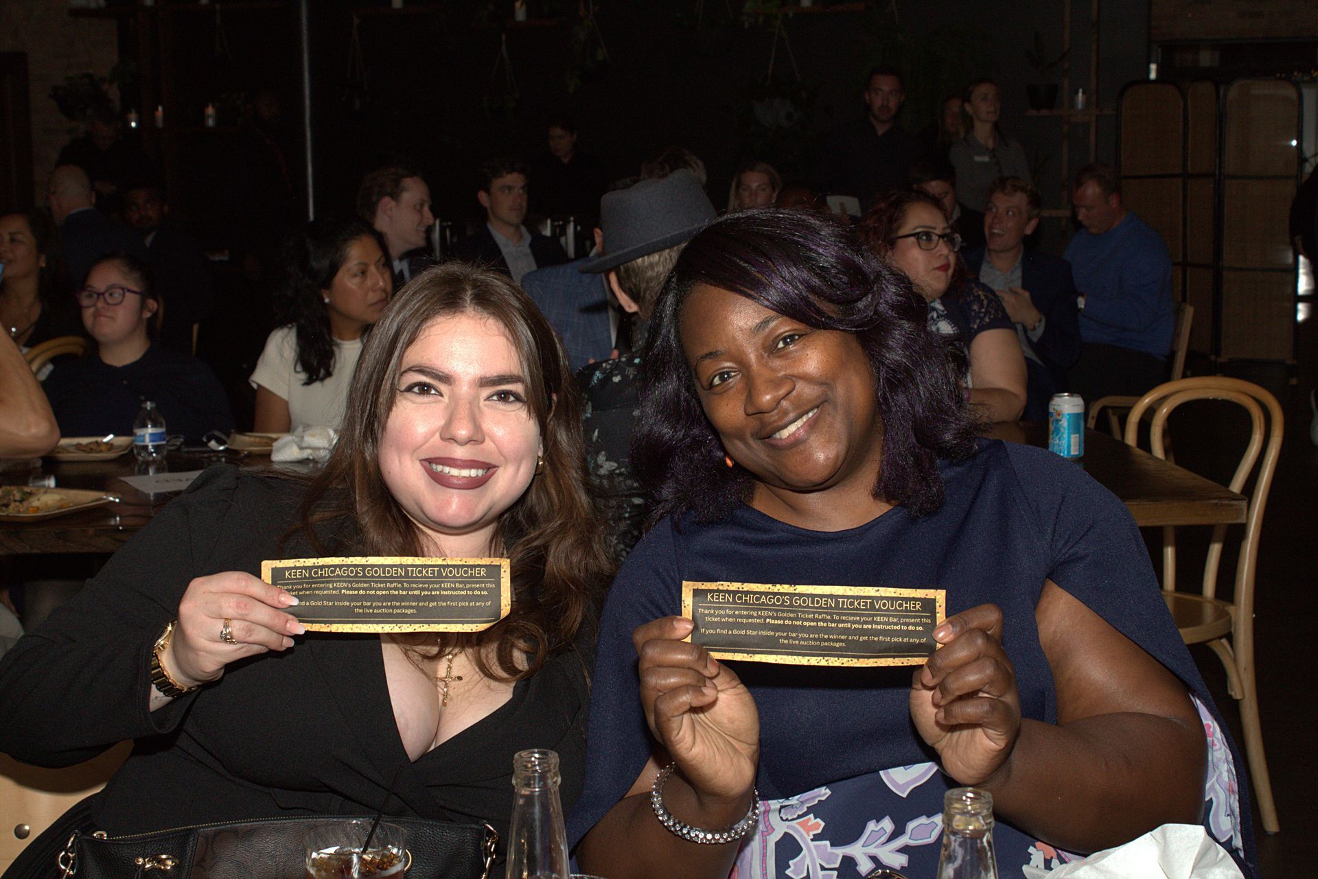 Two attendees hold their Golden Ticket vouchers