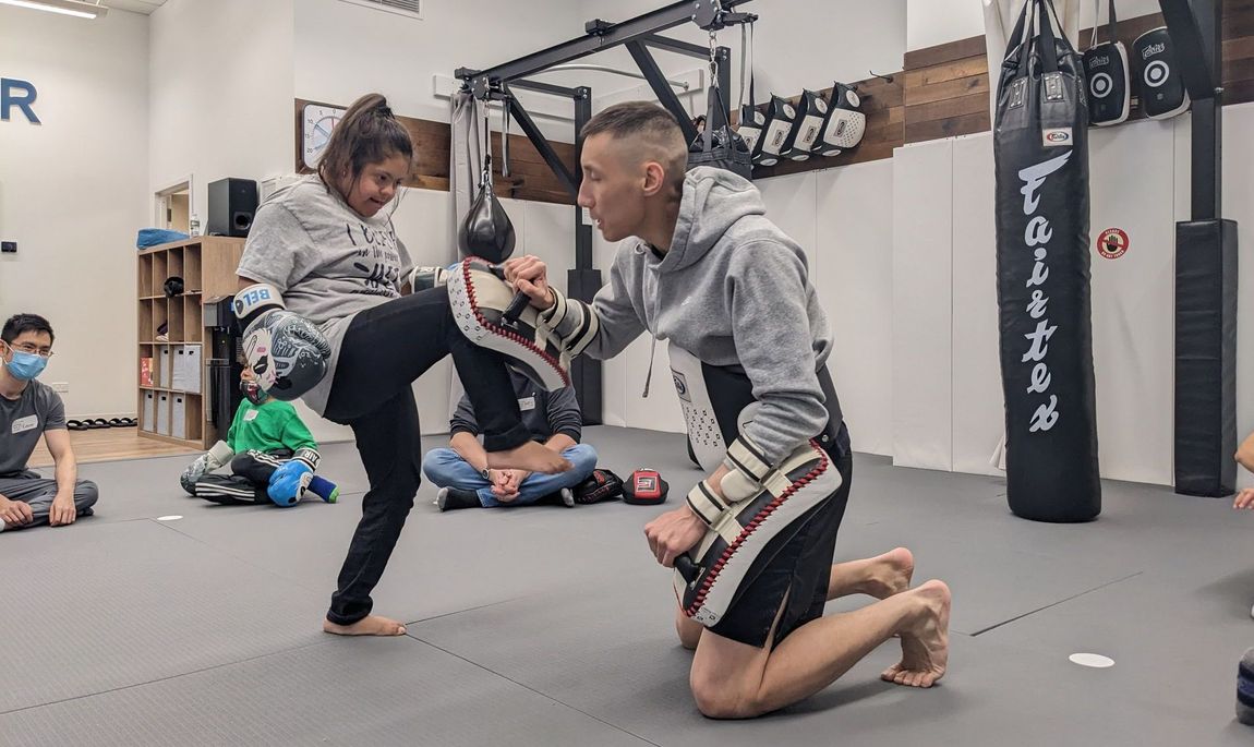 A young woman with down syndrome practices thai boxing