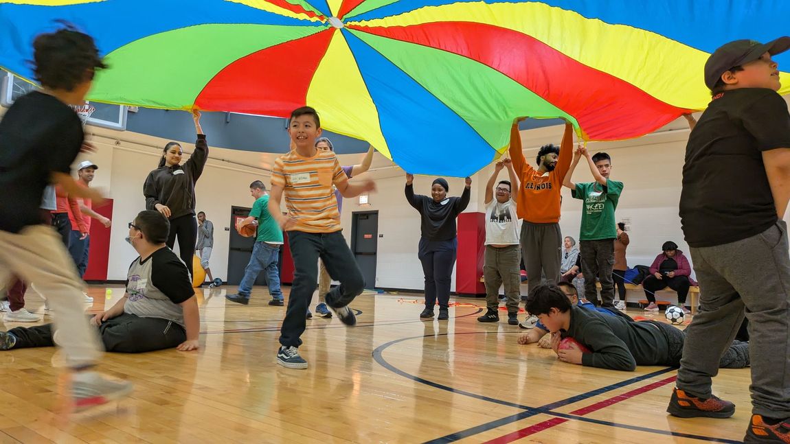 A group of KEEN Chicago athletes play under a parachute