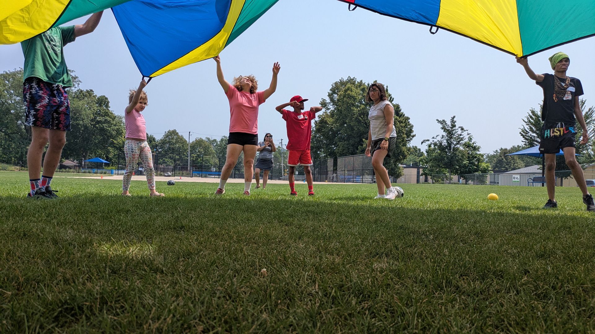KEEN athletes play outdoors under a parachute