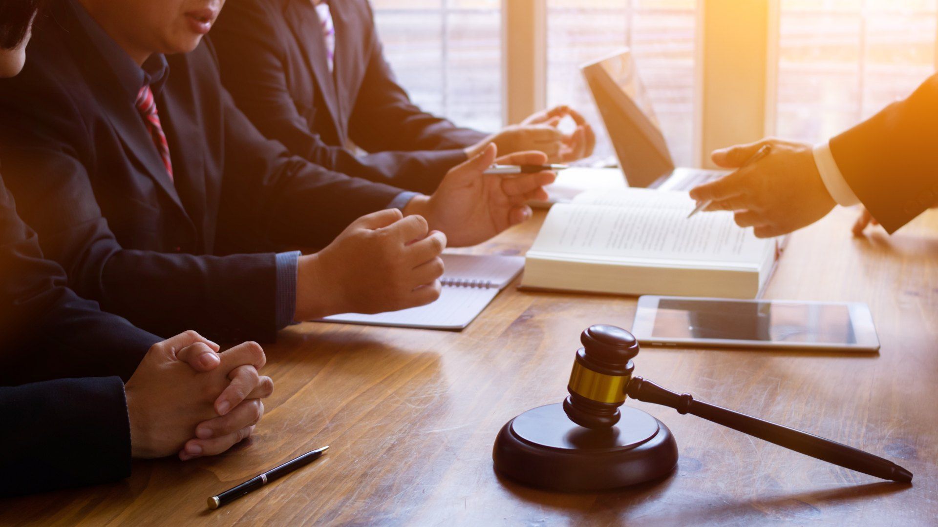 A group of people are sitting at a table with a judge 's gavel.