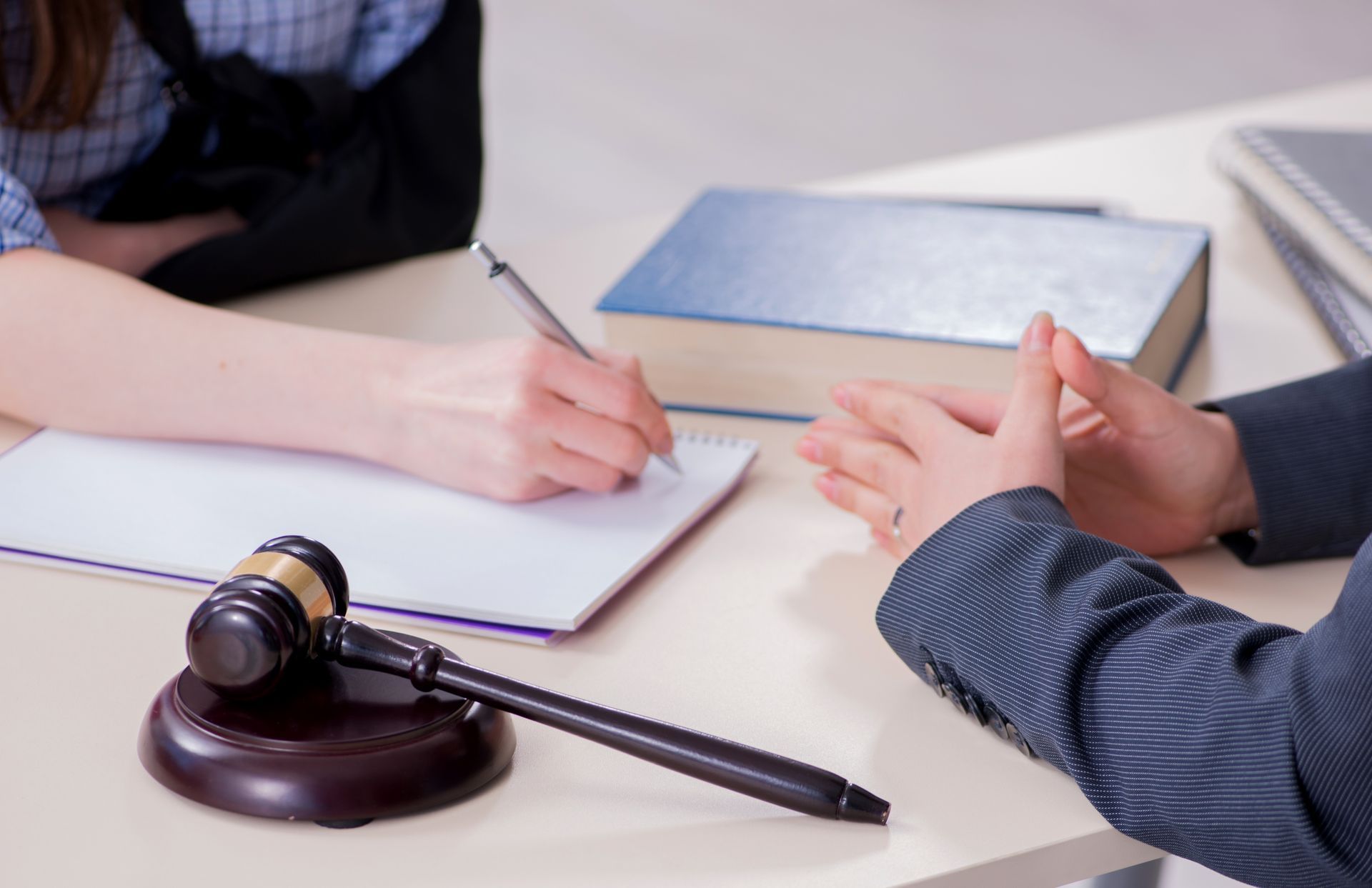 A man and a woman are sitting at a table with a judge 's gavel.