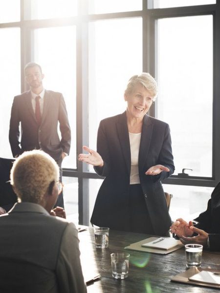 A woman is giving a presentation to a group of people at a conference table.