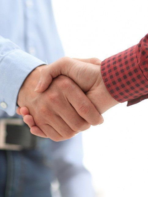 Two men are shaking hands on a white background.