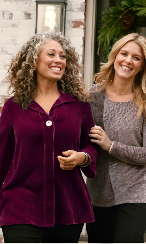 Two women smiling, walking outside.