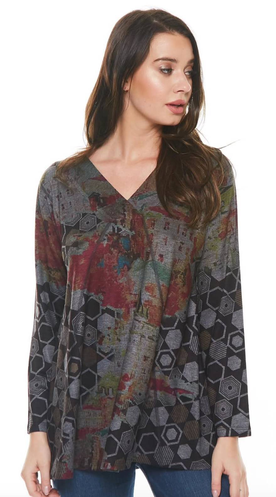 Woman in a long-sleeved, V-neck top with a geometric pattern. The top features a mix of colors and an abstract design.