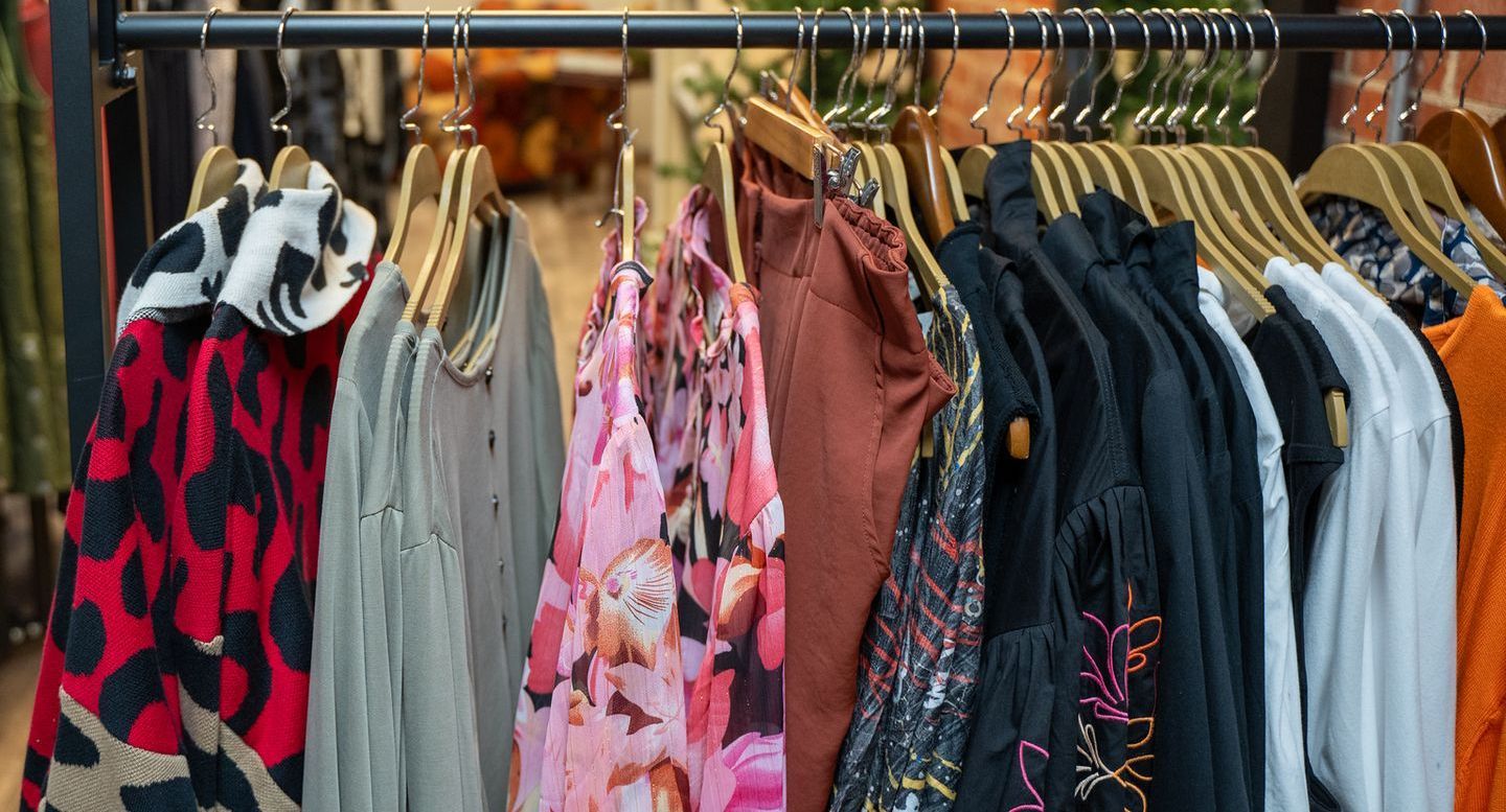 Clothing rack filled with various garments in different colors and patterns.