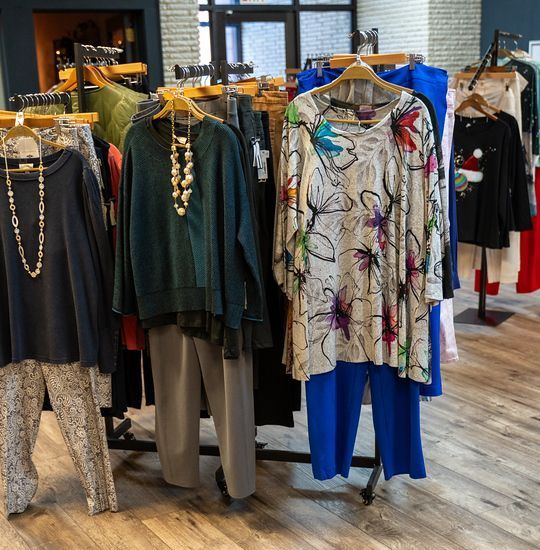 Clothing racks displaying a variety of women's apparel in a boutique setting.