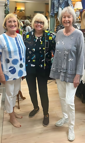 Three women smiling in a store.