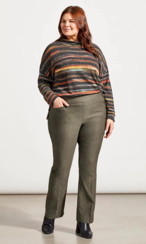 Woman in olive green pants and a striped sweater, posing in a studio.