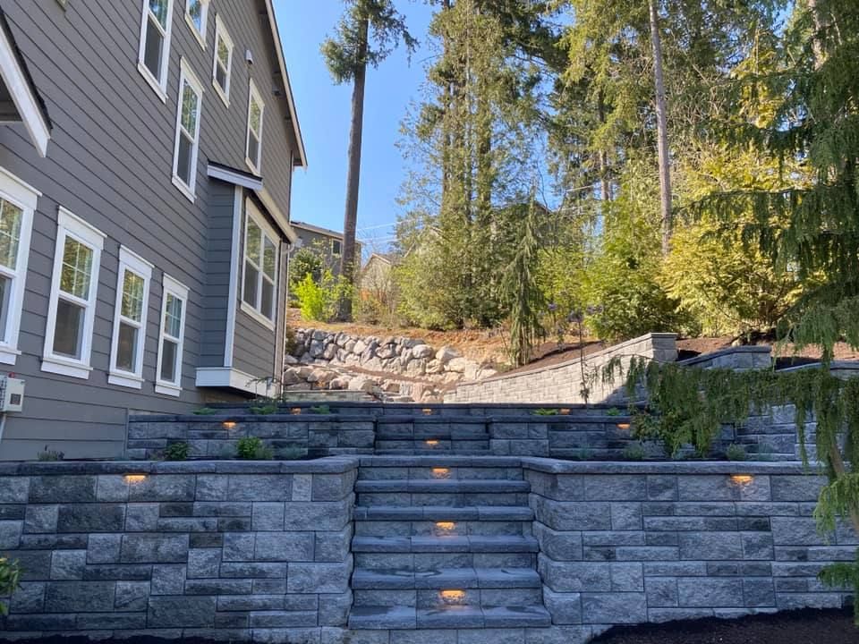 A house with a stone wall and stairs leading up to it.