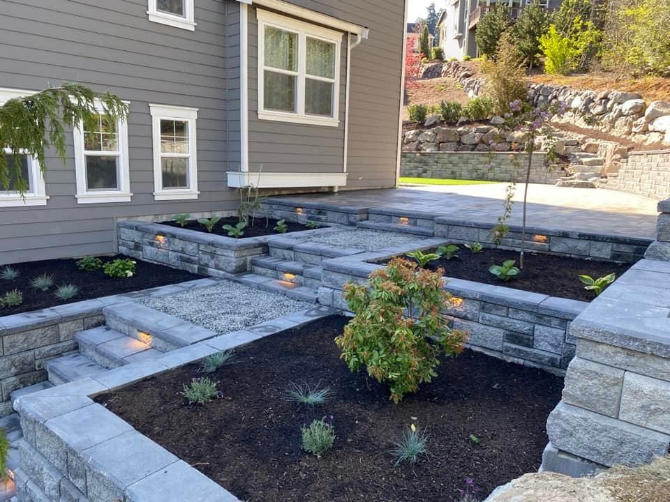 A house with a brick walkway and planters in front of it.