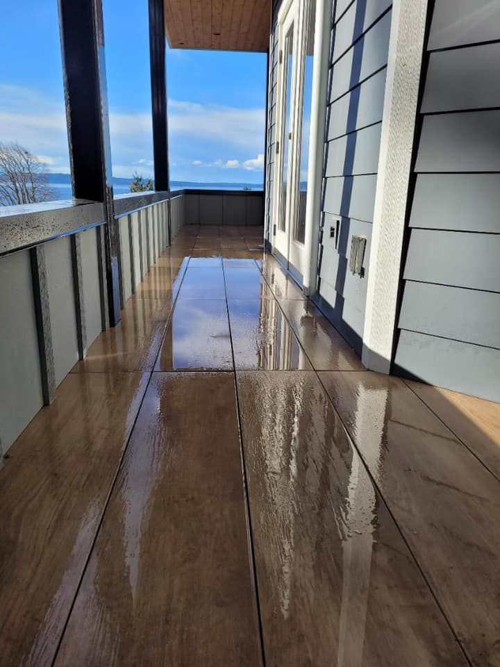 A long wooden walkway leading to a balcony with a view of the ocean.