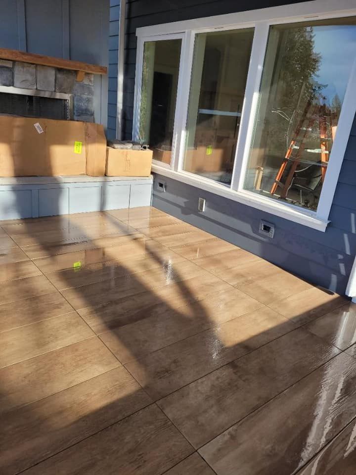 A patio with a wooden floor and a large window.