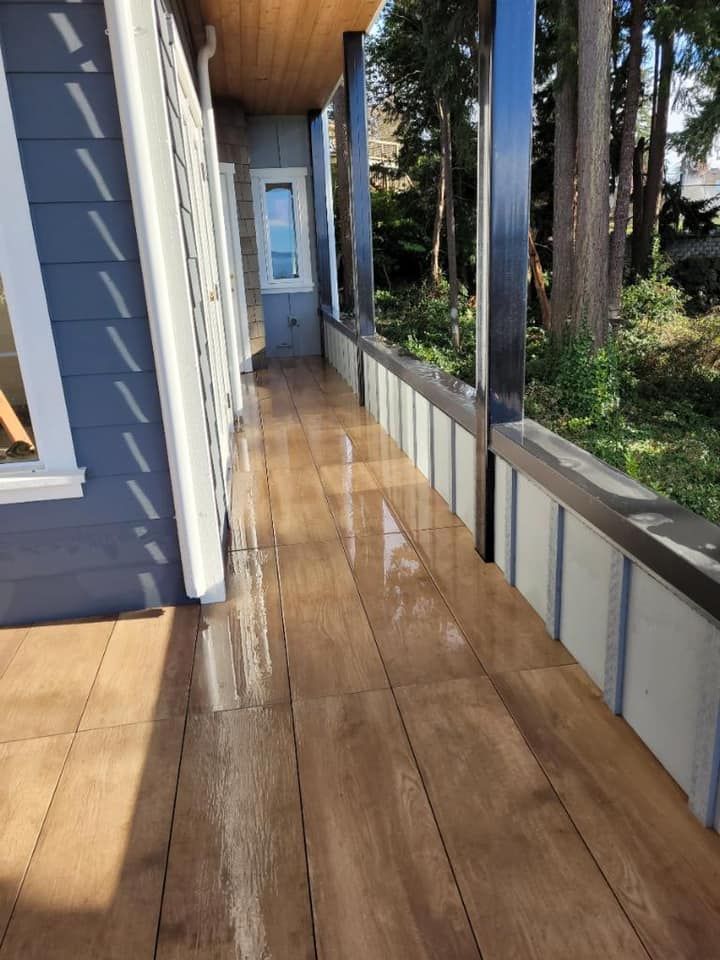 A long wooden walkway leading to a house with trees in the background.
