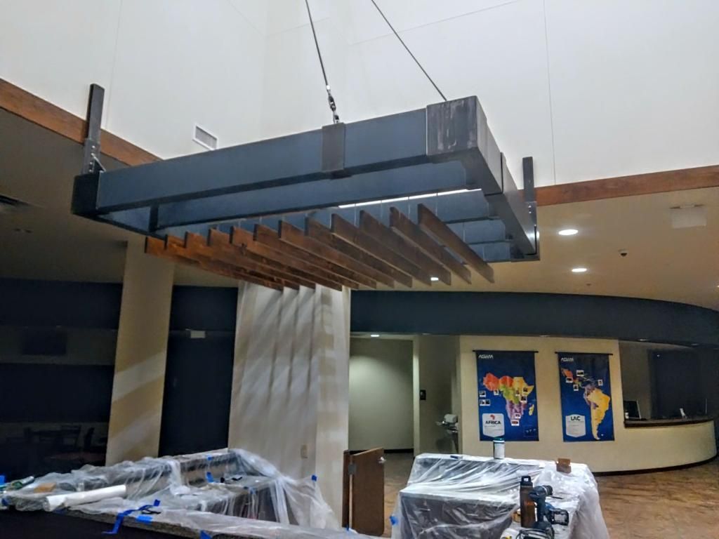 A large metal structure is hanging from the ceiling of a building.