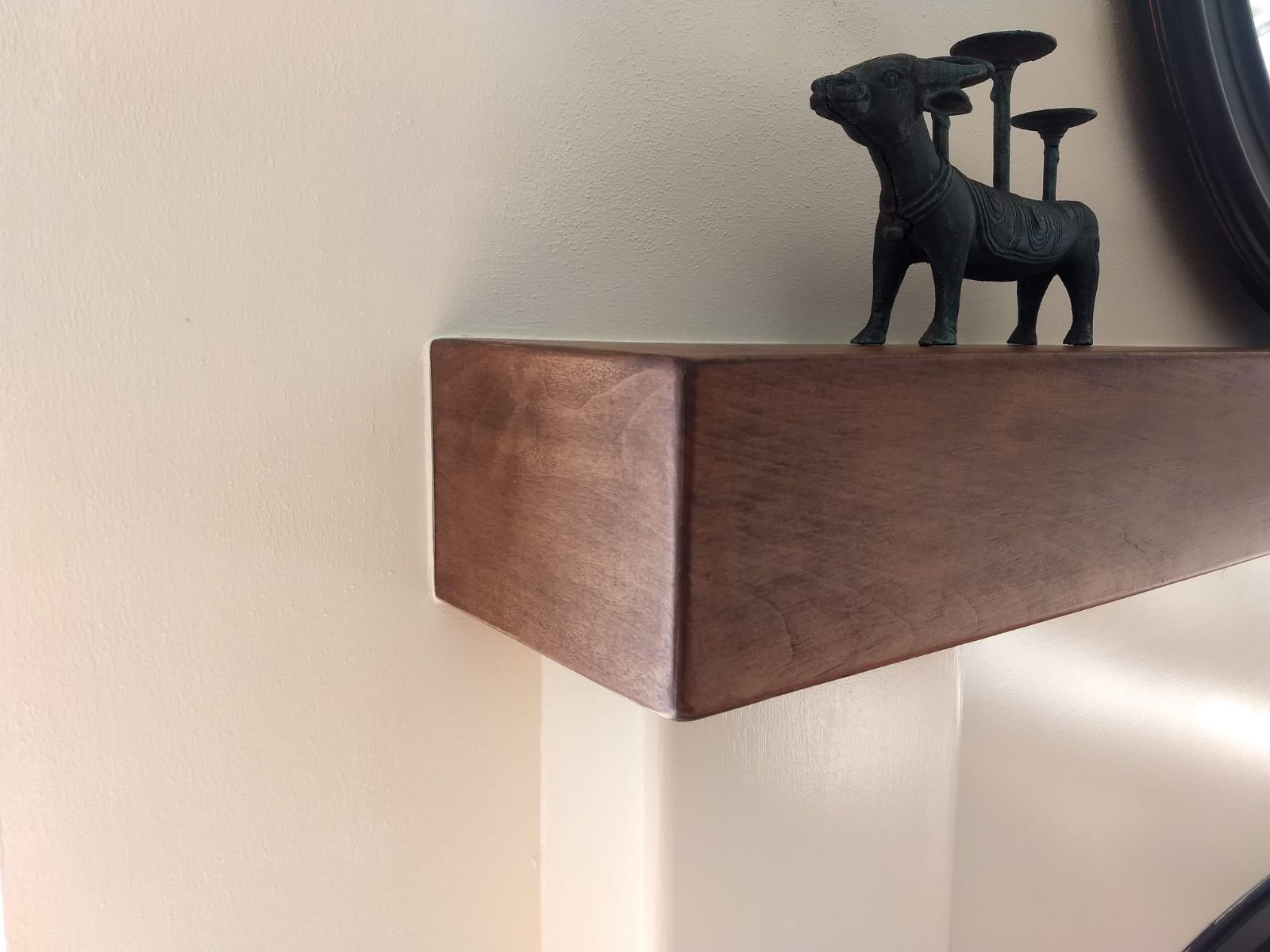 A wooden shelf with a statue on top of it
