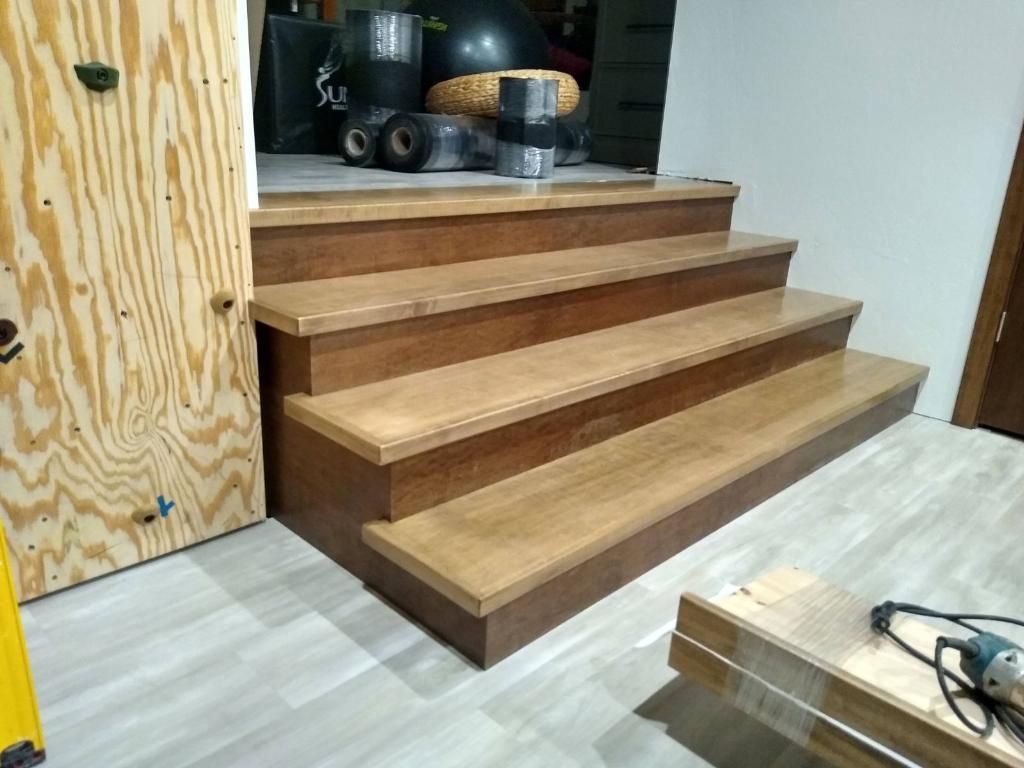 A wooden staircase is being built in a room.