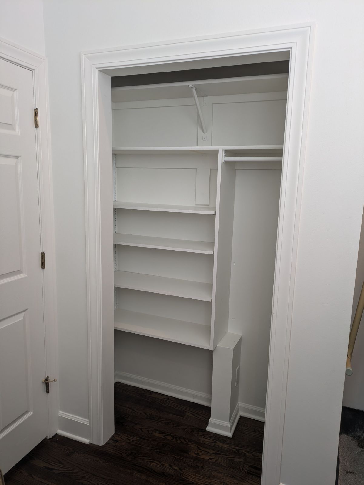 A closet with shelves and a door in a room.
