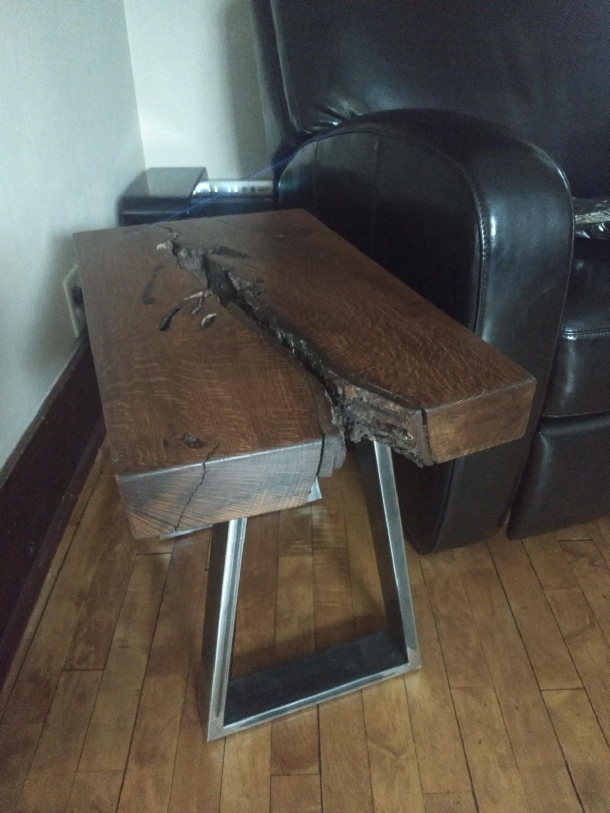 A wooden table in a living room next to a chair