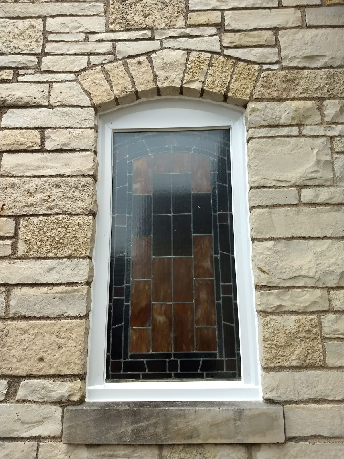 A brick wall with a stained glass window on it