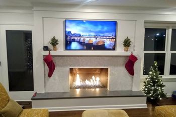 A living room with a fireplace and a flat screen tv