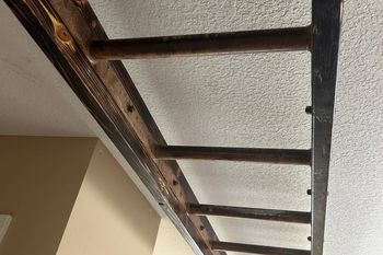 A ladder is hanging from the ceiling in a room