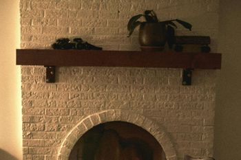 A rocking chair sits in front of a fireplace