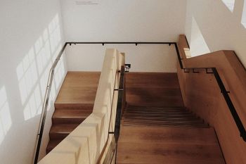 A set of wooden stairs with a metal railing