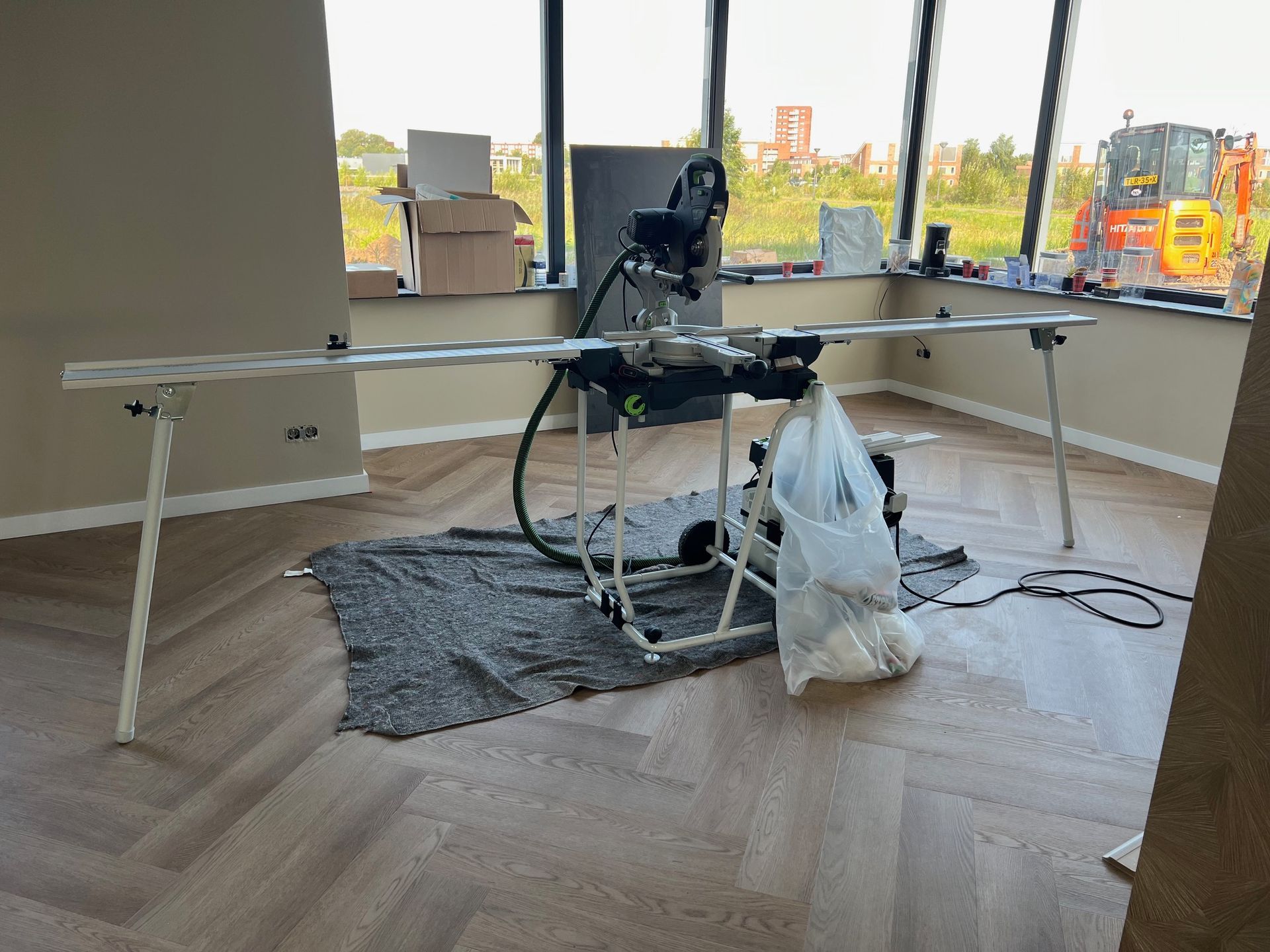 Een cirkelzaag staat op een houten vloer in een kamer.